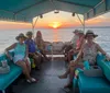 A group of people are enjoying a boat trip on the water at sunset