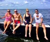 A group of people are sailing on a trimaran enjoying a sunny day on the water