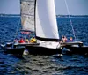 A group of people are sailing on a trimaran enjoying a sunny day on the water