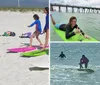 A person in a tie-dye shirt is posing on a surfboard on the sand with two children doing the same behind them under a bright sun with a beach umbrella and various beach items around