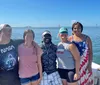 A group of people enjoys a sunny day on a boat named Miss AnnaLisa with one person swimming in the foreground as seen against a backdrop of clear skies and calm waters