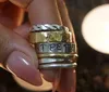 A person is holding a stack of rings with varied designs including one that says ST PETE