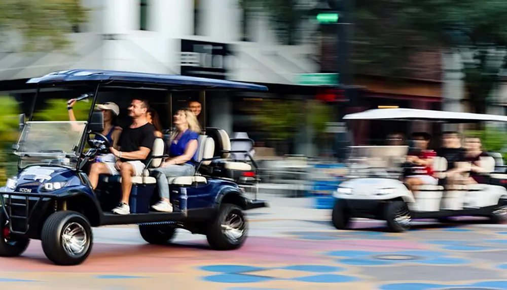 Two golf carts filled with passengers are in motion on a colorful urban street captured with a motion blur effect to convey speed