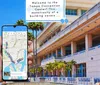 A persons hand is holding a smartphone with a map on the screen displaying the location of the Tampa Convention Center which is shown in the background of the photo