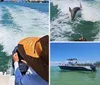 Two people are watching a dolphin leap out of the water behind their boat