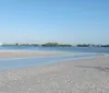 Two people are watching a dolphin leap out of the water behind their boat