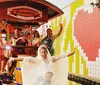 A group of people is joyfully riding a pedal-powered bar on wheels down a street