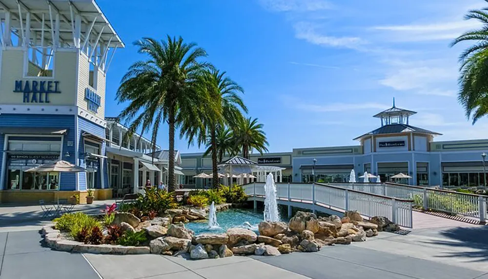 A sunny day at a palm-lined outdoor shopping center with a fountain and a building labeled MARKET HALL