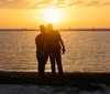 A boat full of passengers is cruising on calm waters at sunset creating a tranquil and beautiful scene