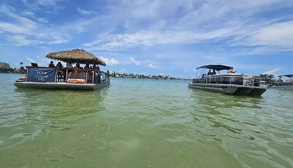 Two pontoon boats one with a thatched roof and passengers are floating on a calm greenish body of water under a partly cloudy sky