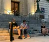 Two people are engaging in what appears to be a playful activity involving sticks on a city street