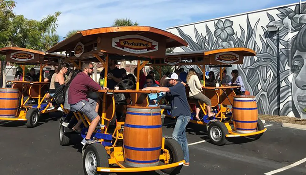 A group of people are enjoying a ride on a multi-passenger pedal-powered bar on wheels called a pedal pub