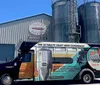 A colorfully wrapped Brew Bus is parked outside the Cigar City Brewing facility advertising brewery tours and various private events