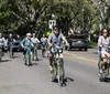 A group of people are enjoying a sunny day cycling together on a tree-lined street