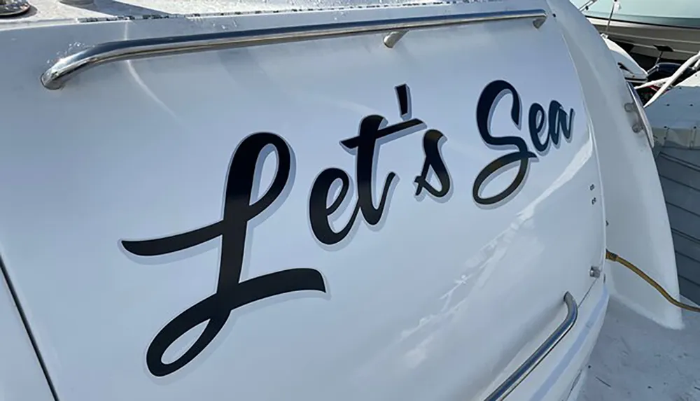 The image shows a close-up of a section of a boat with the stylized text Lets Sea printed on its hull suggesting a playful nautical theme