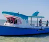 A novelty boat designed to look like a shark complete with a gaping mouth is carrying passengers on a clear day at sea
