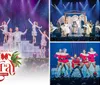 A group of performers in white costumes is dancing on stage in front of an audience with festive holiday decorations around them