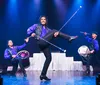 A dynamic performance with a woman dancing energetically in the foreground flanked by two drummers playing enthusiastically