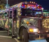 Four joyful people dressed in festive Christmas attire posing in front of a bus named BUS-TED