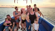 A group of people is enjoying a sunset boat ride together.