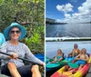 Two people are smiling while kayaking among mangroves both holding blue paddles and wearing sun hats