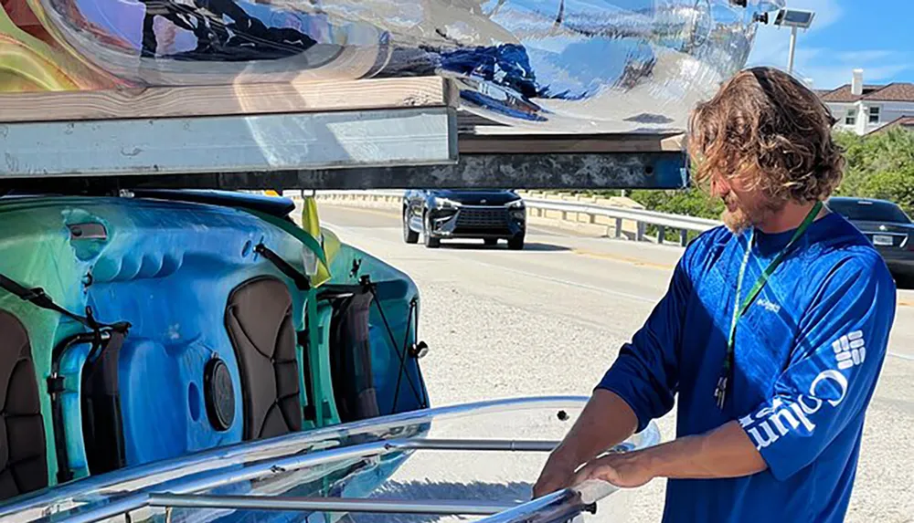 A person is standing by a distorted reflection of cars on what appears to be a highly polished and curved metal surface of a large structure by the roadside