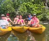 A group of people are enjoying a sunny day kayaking together on a calm river surrounded by lush greenery