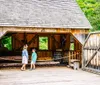 A person in historical attire is giving a demonstration or presentation in a rustic wooden interior possibly a historic or educational setting