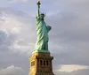 A group of people is sailing near the Statue of Liberty on a sunny day