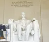 The image depicts the iconic statue of Abraham Lincoln at the Lincoln Memorial in Washington DC with an inset of the Liberty Bell symbolizing American independence and history