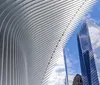 This image captures the distinctive architecture of the Oculus structure in Lower Manhattan with surrounding skyscrapers against a clear blue sky