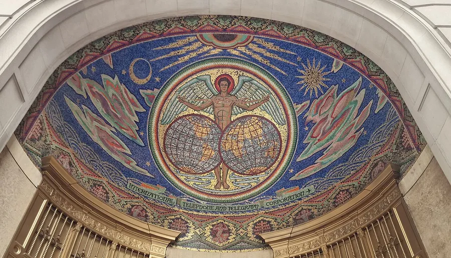 The image shows an intricate mosaic arch depicting a human figure with wings, standing between two globes, surrounded by celestial motifs and the words International Telephone and Telegraph Corporation.