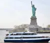 A ferry filled with passengers sails near the Statue of Liberty on a cloudy day