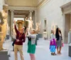 Visitors are viewing and photographing paintings on display in an art gallery