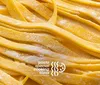 The image shows fresh uncooked fettuccine pasta with a dusting of flour along with text suggesting it is related to a special pasta cooking class