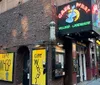 A person is holding an image of the iconic facade of the CBGB music club in front of the current John Varvatos store which now occupies the same location