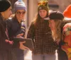 A group of people some wearing colorful winter hats gather around a person holding a tablet engaged in what seems to be an interesting interaction or discussion in an outdoor setting