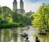 Cyclists and pedestrians enjoy a sunny day on a tree-lined path with an imposing building in the background