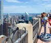 Visitors enjoy the view of a sprawling cityscape from a high vantage point with coin-operated binoculars available for a closer look