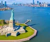 The image shows an aerial view of the Statue of Liberty with a backdrop of the Manhattan skyline and surrounding waters