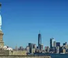 The Statue of Liberty stands tall against a blue sky with wispy clouds