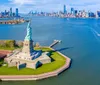 The Statue of Liberty stands tall against a blue sky with wispy clouds