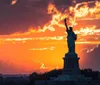 The Statue of Liberty stands tall against a blue sky with wispy clouds