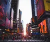 The image captures a bustling Times Square at twilight with illuminated advertisements towering over pedestrians and traffic