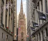 The image captures a narrow urban street flanked by tall buildings adorned with holiday decorations leading to a gothic-style church with flags and a star-shaped light display visible