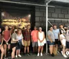 A group of smiling people are posing for a photo in front of a large promotional poster for a theatrical performance