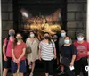 A group of smiling people are posing for a photo in front of a large promotional poster for a theatrical performance