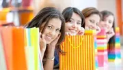 A group of cheerful women are holding colorful shopping bags, suggesting they have been on a shopping spree.