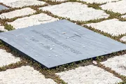 This image displays a grave marker inscribed with the name 