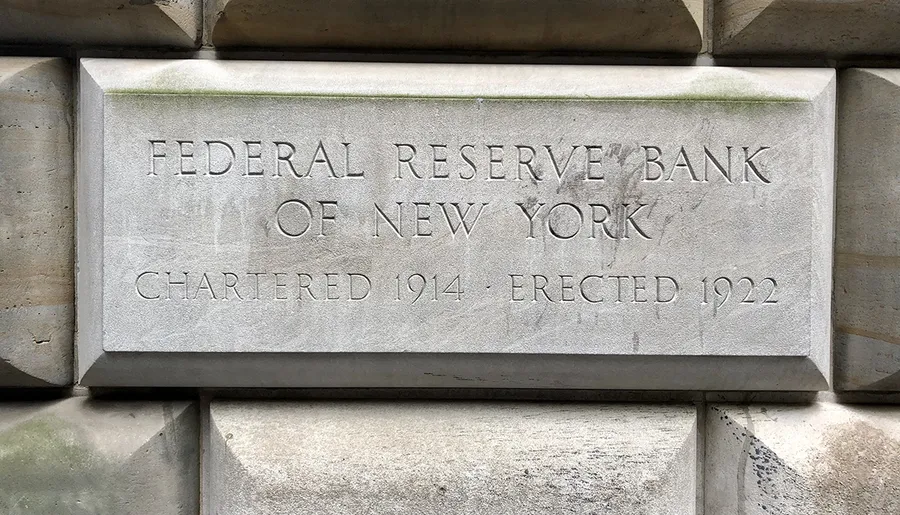 The image shows an inscription on a stone indicating FEDERAL RESERVE BANK OF NEW YORK CHARTERED 1914 - ERECTED 1922.